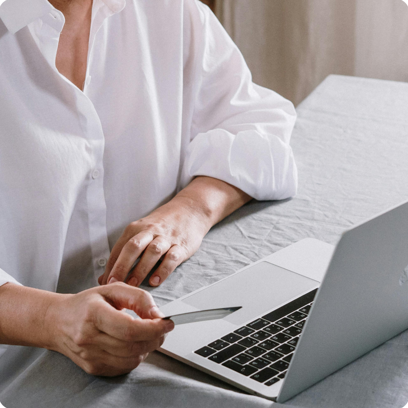 Woman using credit card to make payment on her computer using WiFi